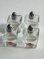 Four crystal shakers front view showing metal tops