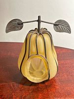 Front view of yellow satin glass pear-shaped tealight holder showing cage and opening