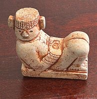 front view of carved stone figurine showing facial features and pose