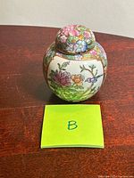 Front view of porcelain ginger jar with lid and floral bird design
