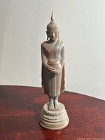 Front view of hand-carved stone Buddha on pedestal