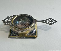 Top view assembled tea strainer on drip tray showing patina