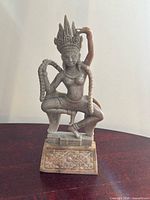 Front view of soapstone apsara carving on base