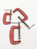 All three red metal C-clamps laid out