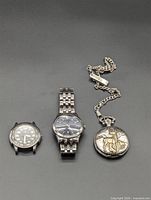 Three watches laid out side by side on grey background