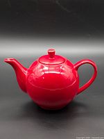 Side view of Maxwell Williams red teapot with lid
