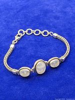 Full view of sterling silver bracelet laid flat showing three oval stones and clasp