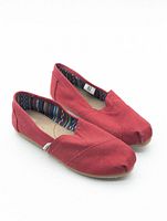 Angled view of pair of red TOMS slip-on shoes showing uppers, lining, and outsole