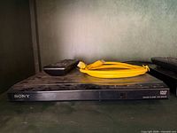 Sony DVP-SR210P CD/DVD player with remote and yellow cable
