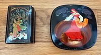 Both lacquer trinket boxes closed, showing painted lids and relative sizes
