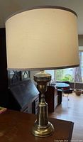 full view of brass lamp with shade in room setting
