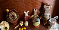 Group shot showing glass bunny, stuffed bunnies, sugar eggs, papier-mâché egg, wooden egg picks, chick figures and basket