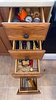 Three open drawers showing varied kitchen utensils