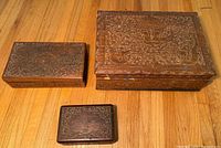 Three carved wooden boxes showing relative sizes and exterior condition