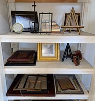 shelving unit showing assorted frames and easels