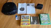 All items in lot: Jensen boombox, two manuals, Roland Micro Cube GX amp, two karaoke box sets, Rolling Stones CD