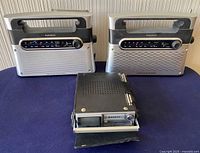 Front view of two RadioShack portable radios and one Sanyo portable radio