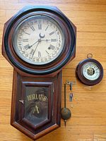 Wall clock with detached parts and barometer laid out