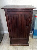 Front view of wooden jelly cupboard showing door, knob, and base
