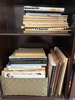 Shelf with woven basket and stacked sheet music books