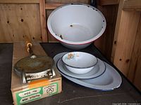 Group shot of pizzelle iron in box and four enamelware pieces