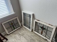 All three stained glass panels standing against wall