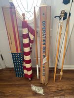 Overall lot showing flag, wooden poles, two original boxes and hardware bag