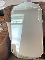 Full view of mirror front showing scalloped shape, etching, desilvering at bottom