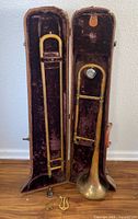 Open case displaying trombone slide, bell, mouthpiece, lyre holder and small accessory