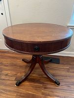 Overall view of mahogany drum side table, showing round top, drawer, pedestal and claw feet