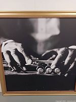 Close-up of framed print showing hands on trumpet