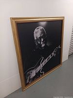 Full view of framed photo print leaning against wall