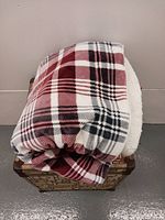 Folded plaid blanket throw on box displaying pattern and thickness