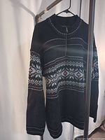 Black half-zip Nordic patterned sweater on hanger