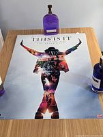 Full view of poster lying flat on table with bottles for scale