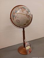 Full view of globe on pedestal stand with booklet bagged at base