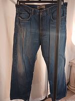 Front view of DKNY straight-cut blue jeans hanging