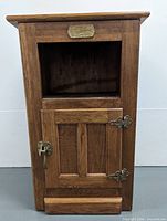 Full front view of oak bedside cabinet showing open cubby, lower door, hardware, overall finish