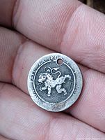 Obverse with rampant lion and legend visible, hole at rim