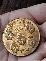 Front of bronze medal showing badges and dates