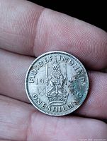 Reverse of 1948 one shilling coin showing crowned lion, date and denomination