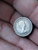 Obverse of 1955 Elizabeth II sixpence held in hand