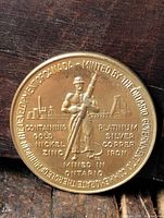 Obverse showing miner, mine scene and metal composition text