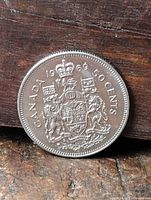 Reverse of 1969 Canadian 50 cent coin showing Coat of Arms and legends