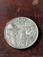 Obverse showing portraits, anniversary text and slogan