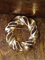 Front view of gold plated wreath brooch pin