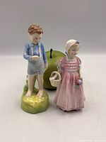 Both Royal Doulton figurines front view with apple for scale