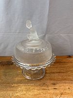 Full view of covered butter dish on wood surface