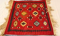 Full view of square kilim rug showing entire pattern and fringe