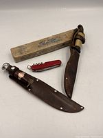 Two sheathed Buck knives, boxed glass cutter, red Swiss Army knife